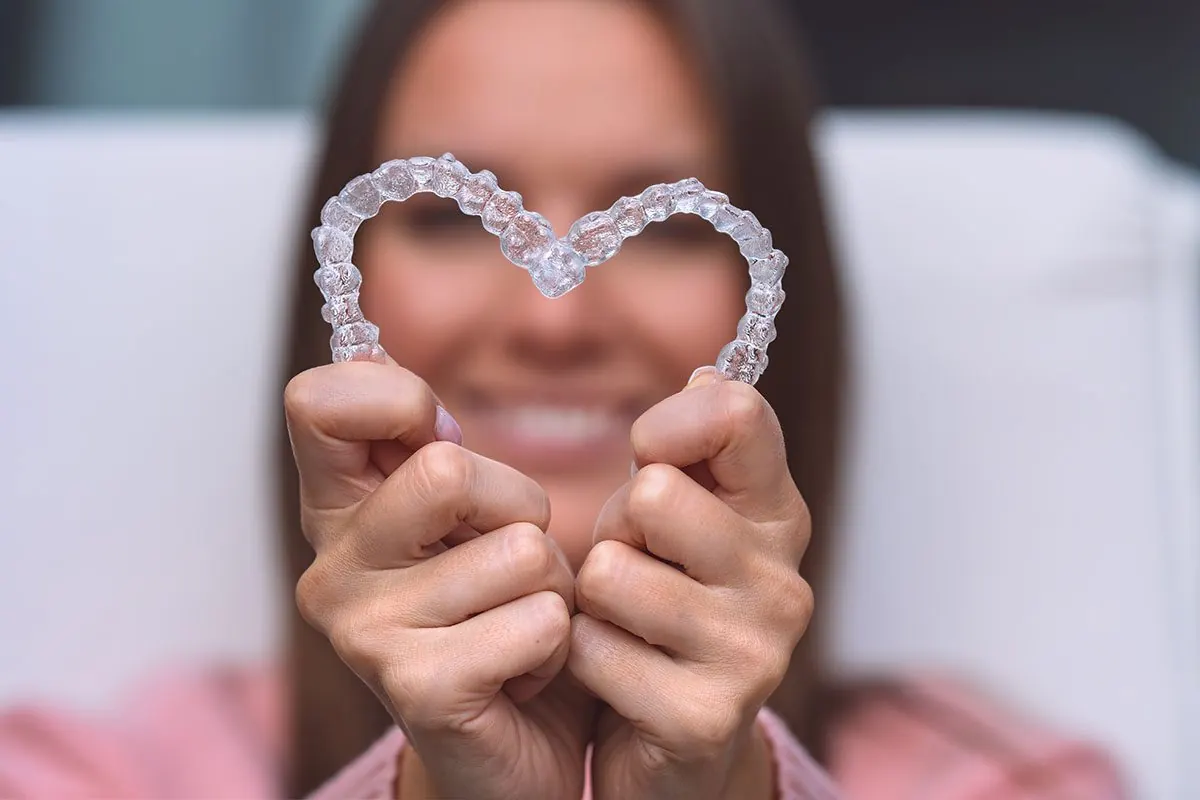 Naine hoiab läbipaistvaid kapesid südame kujul